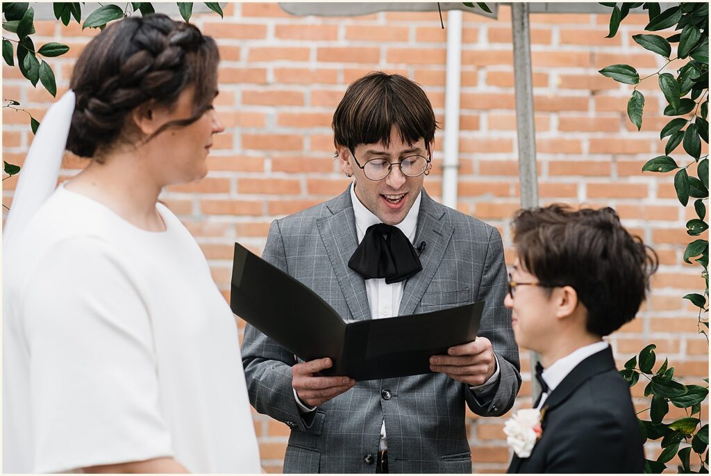 A wedding officiant reads from a script.