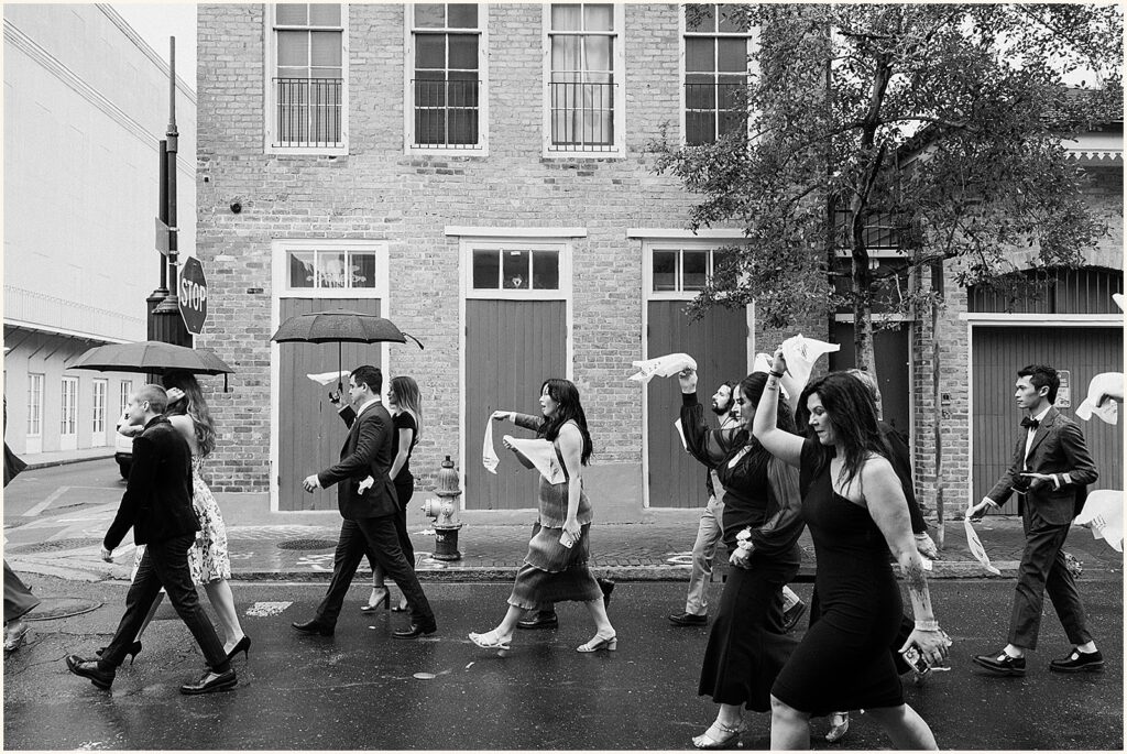 Wedding guests dance down a New Olreans street in a second line.