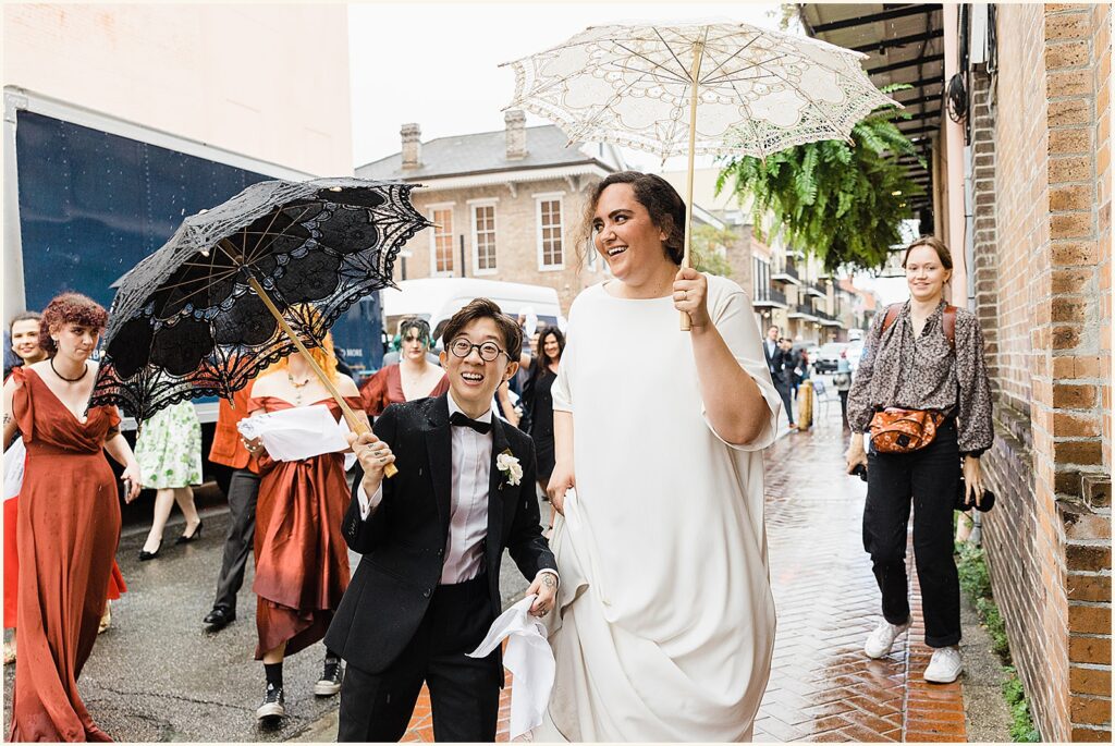 Two marriers carry New Orleans wedding umbrellas.