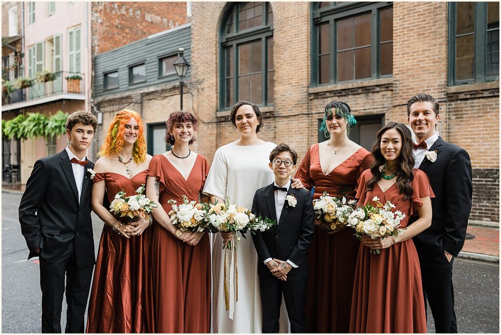 Two marriers pose with members of their wedding party.