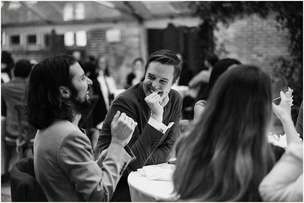 Wedding guests laugh while they talk.