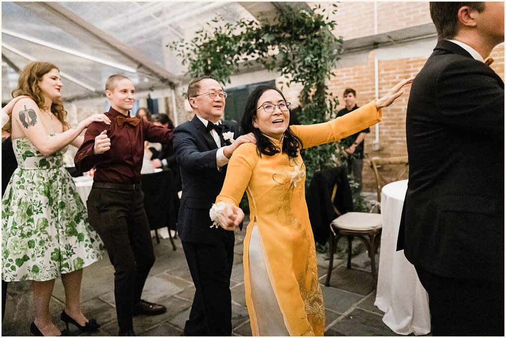 A conga line winds through a wedding tent.