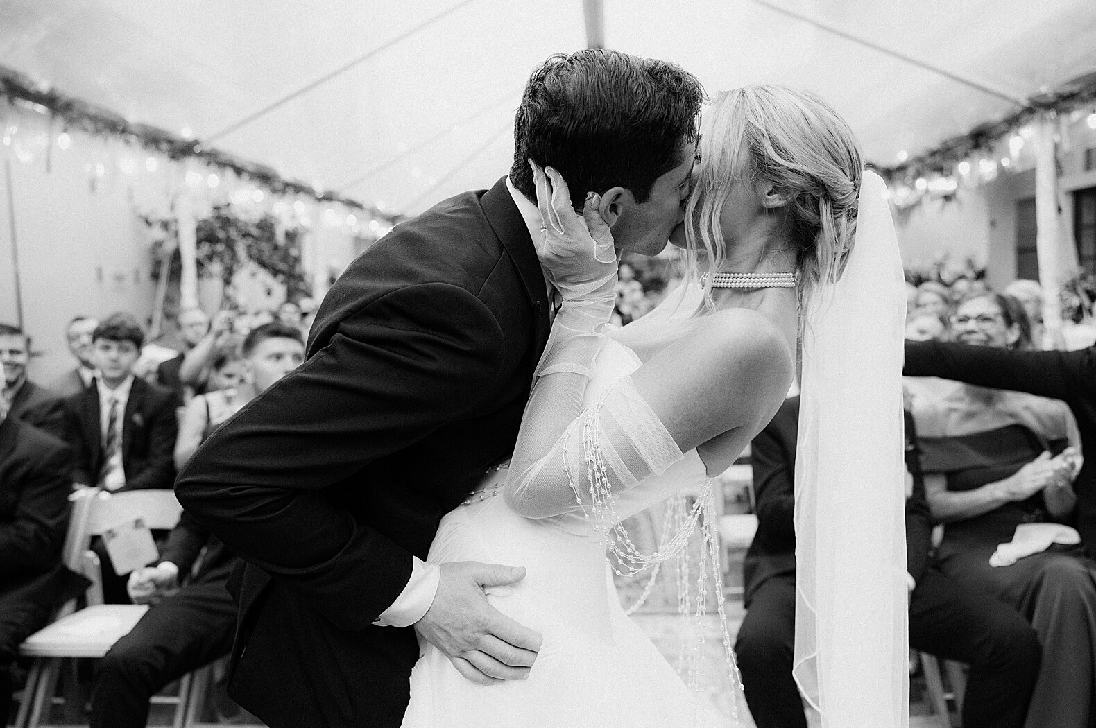 A groom dips a bride for a kiss at the end of a courtyard wedding ceremony at the Royal Frenchmen Hotel.