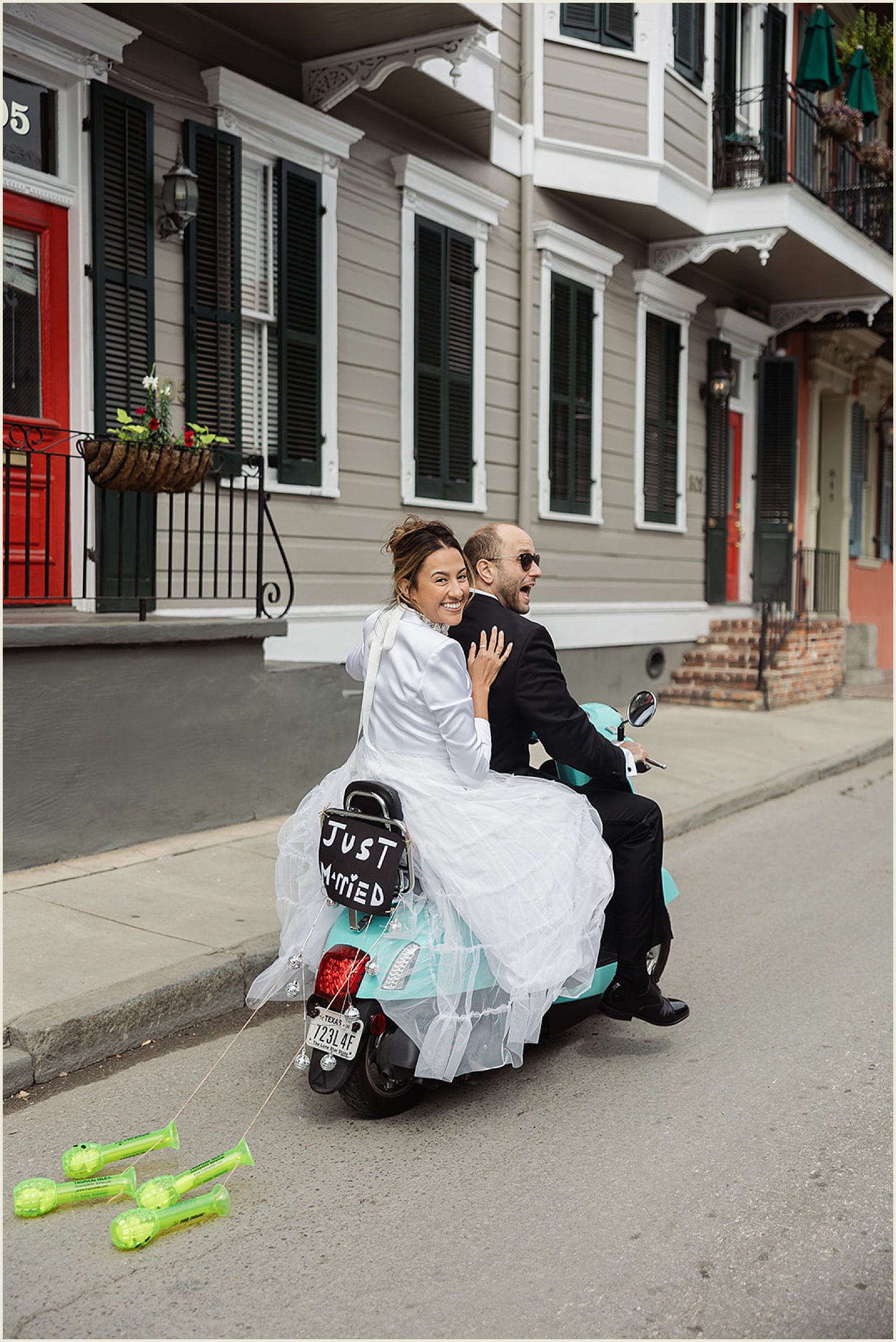 A bride and groom ride a moped through the French Quarter on their way to elope in New Orleans.