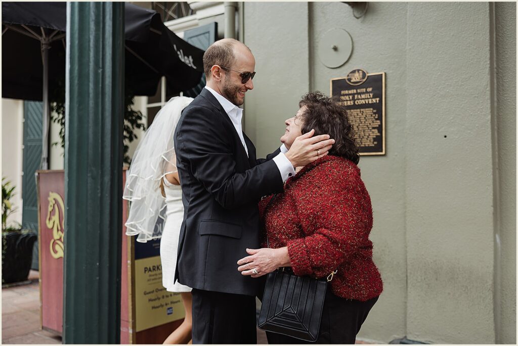 A groom greets his mother on a French Quarter sidewalk.