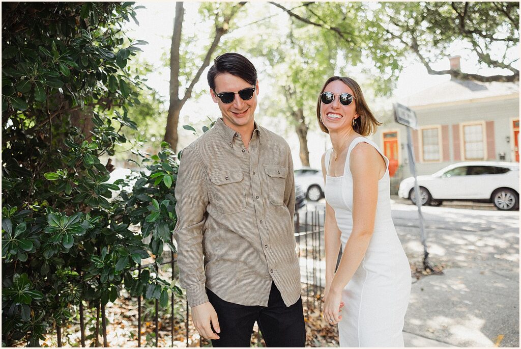 A man and woman laugh on a New Orleans sidewalk.