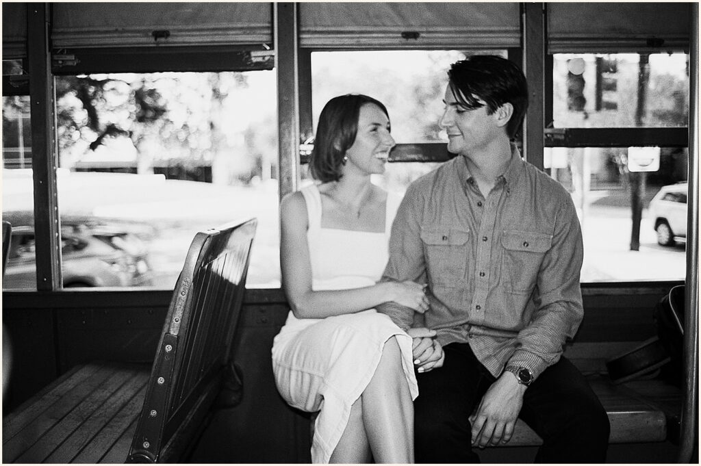 A man and woman sit in a streetcar during a New Orleans photoshoot.
