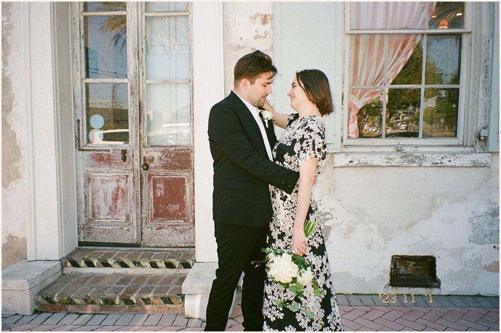 A bride and groom embrace smiling outside Race and Religious.