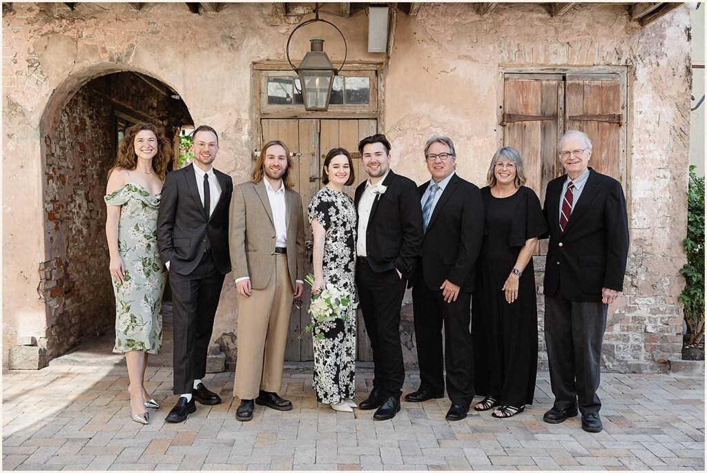 A bride and groom pose with family members for an elopement photo.