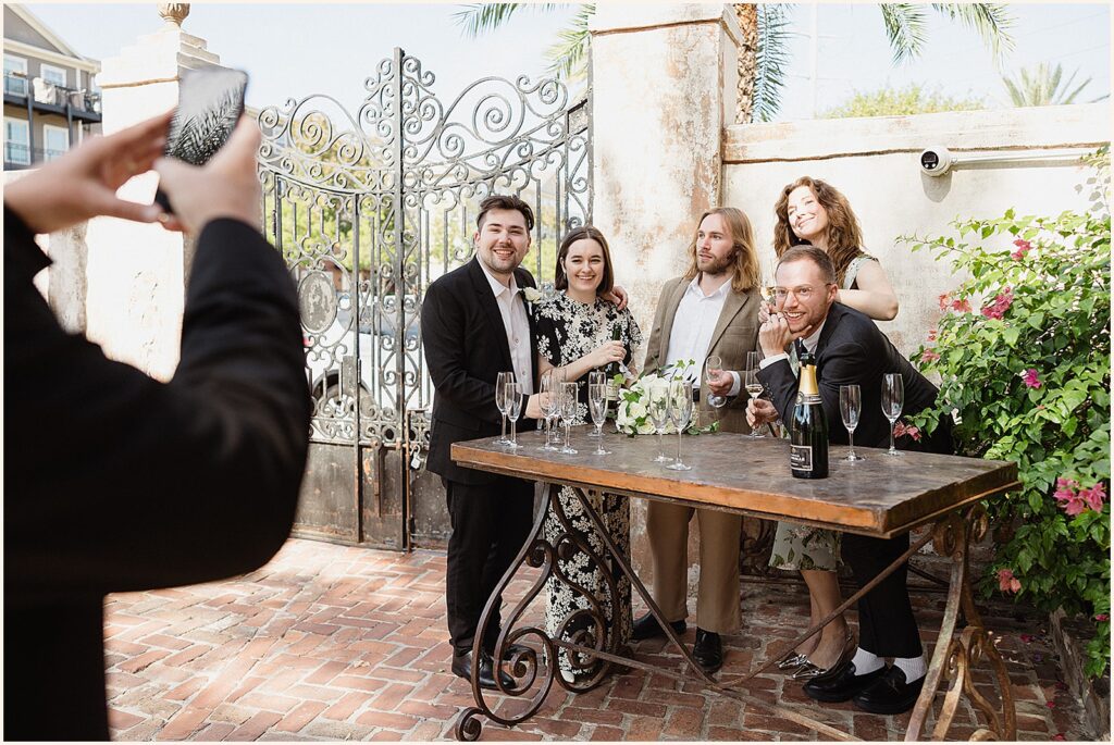 A newlywed couple poses with friends for a photo.