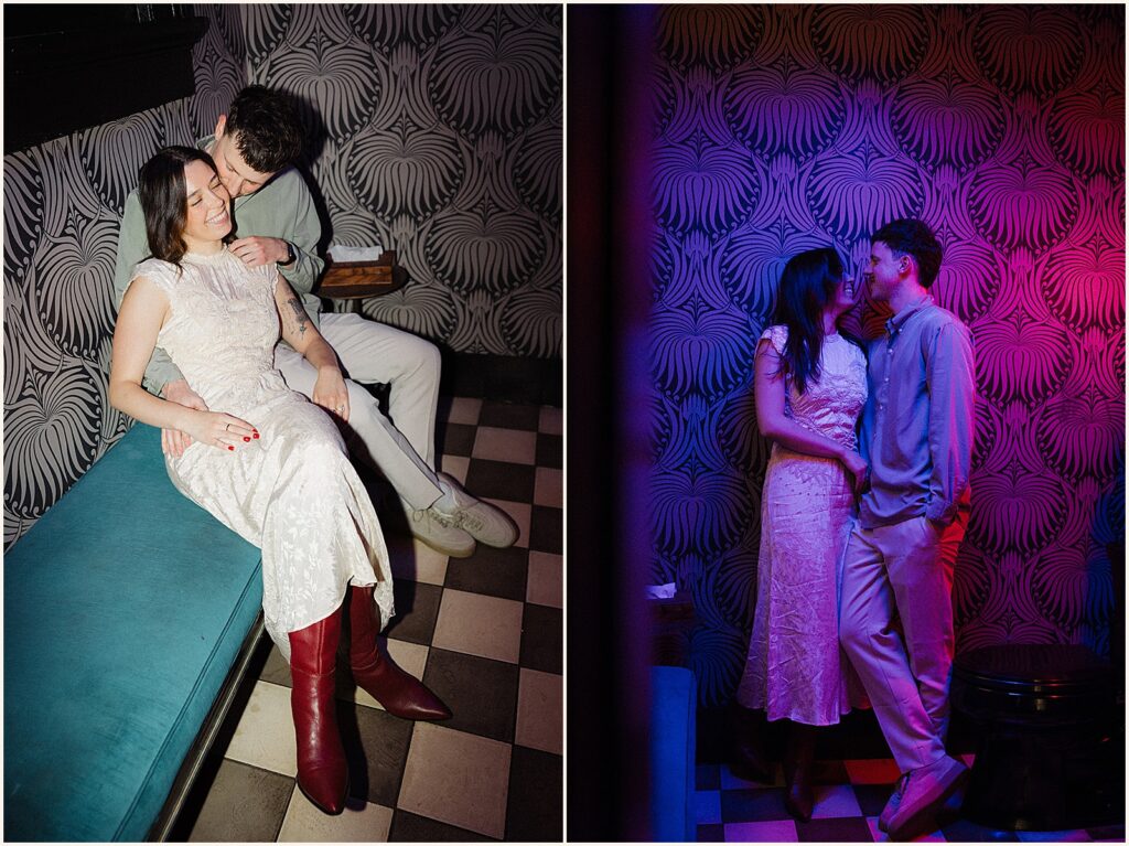 A man and woman kiss in a patch of blue and pink light in creative engagement photos.