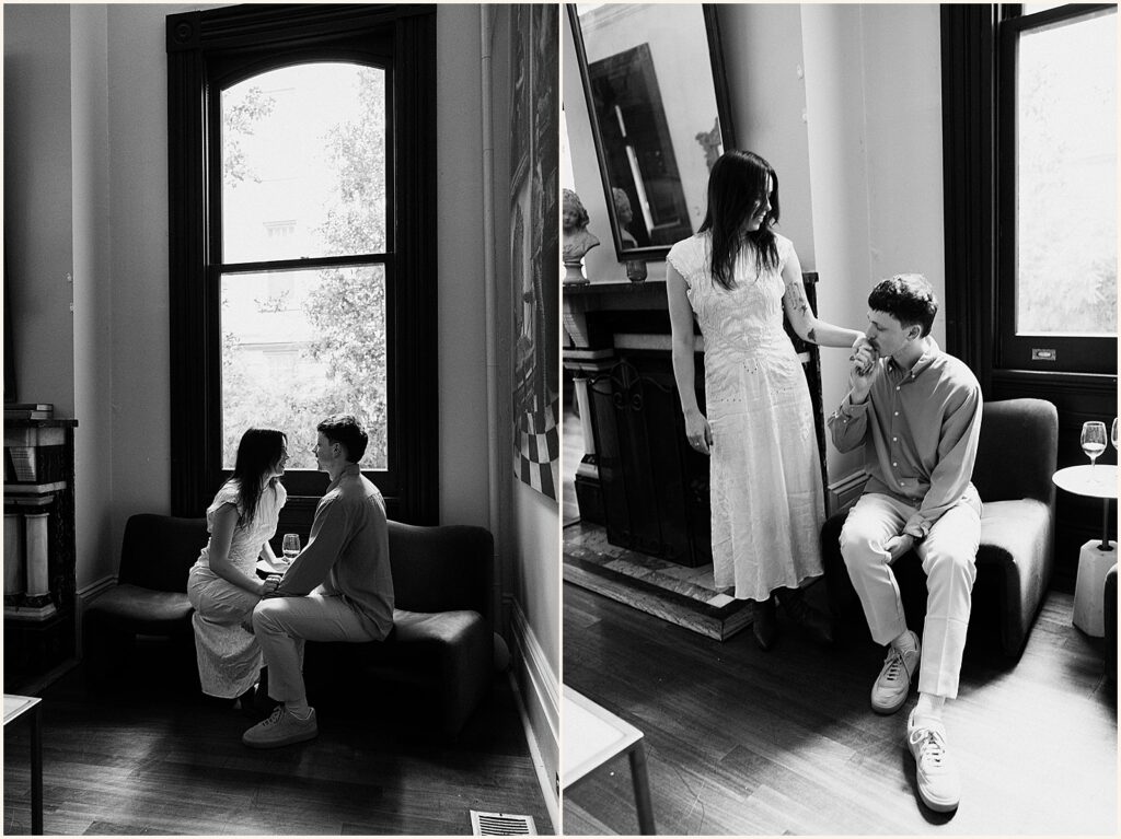 A woman stands beside a seated man in a black and white engagement photo.