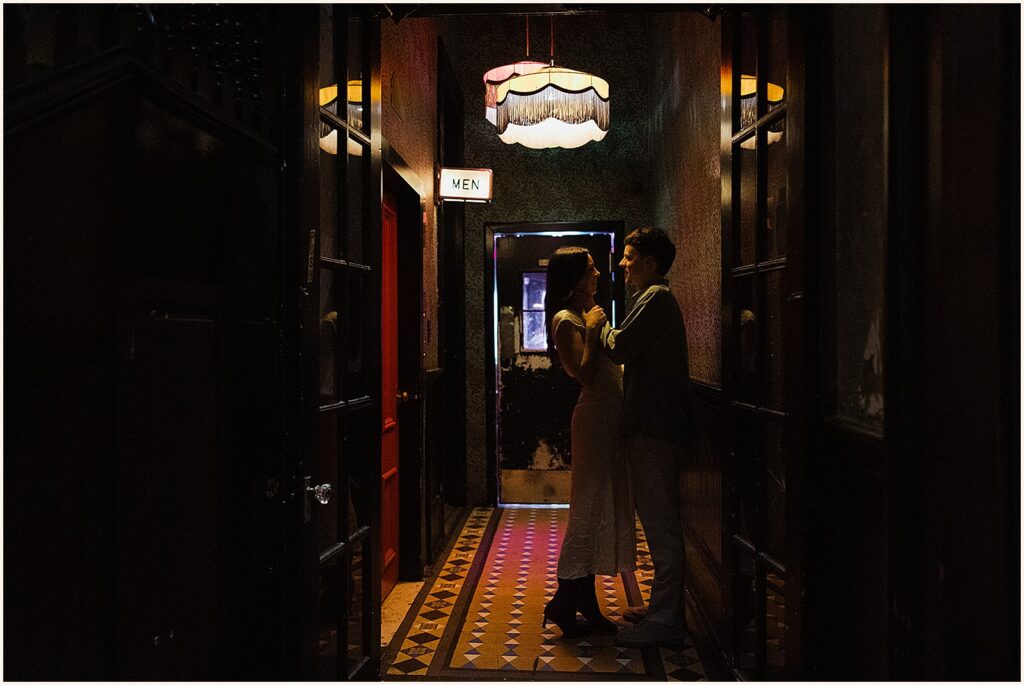 A woman leans towards a man in the hallway of the Columns Hotel.