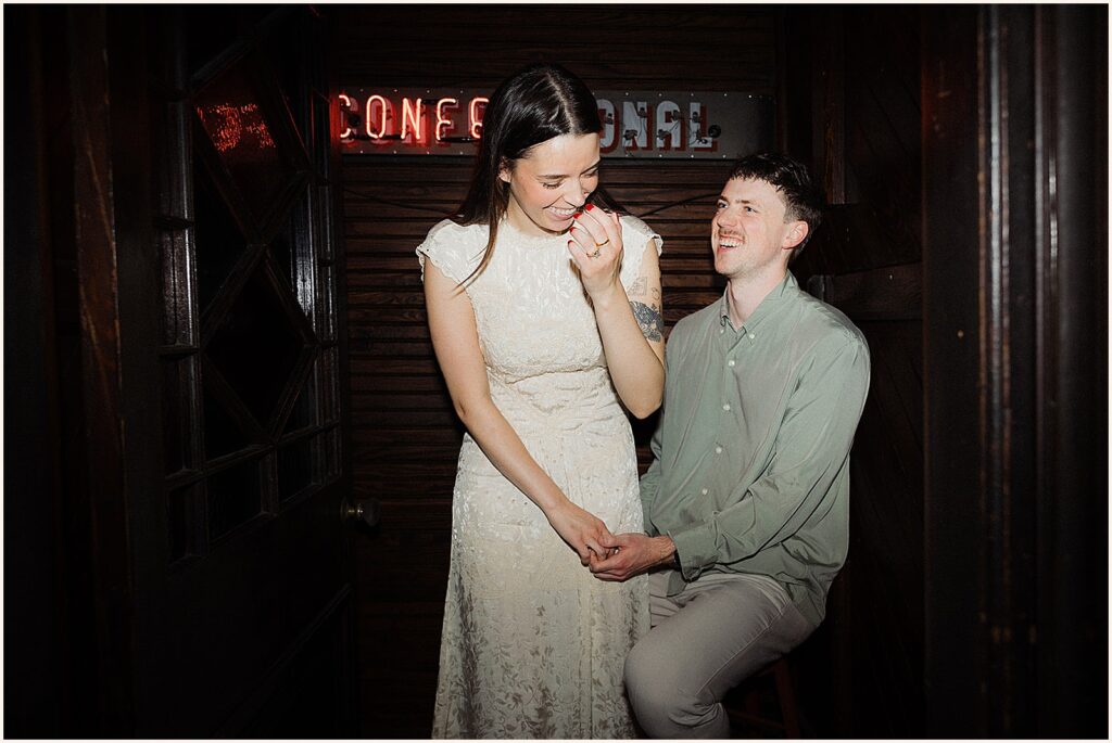 A man and woman laugh in a photo booth in a New Orleans hotel.