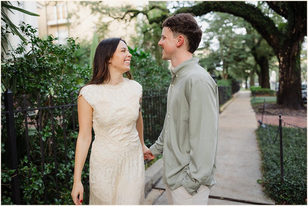 A man and woman turn towards each other on a New Orleans street.